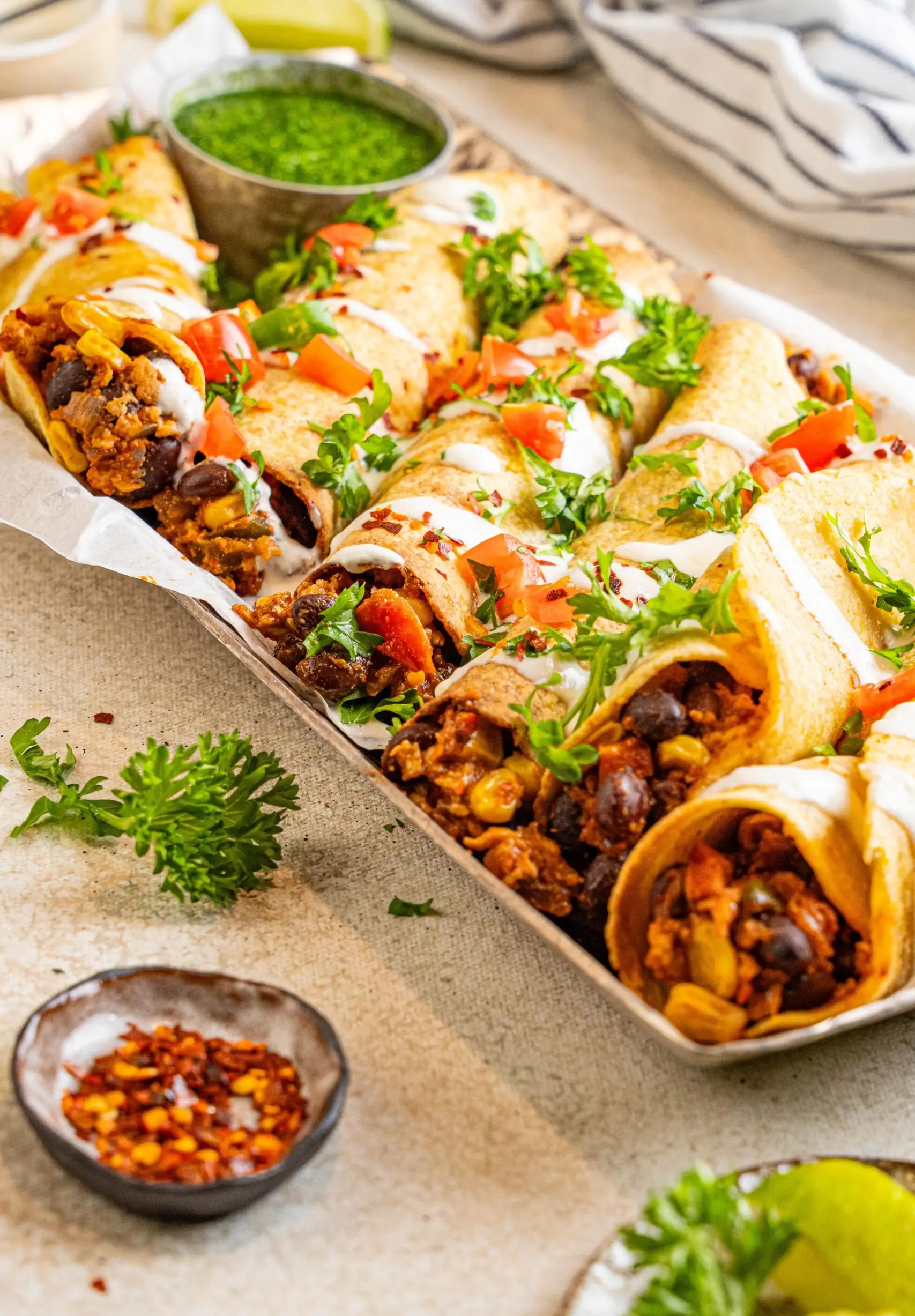 veganski taquitos, postrežen s prilogo zelenega preliva boginje in prelit z veganskim jogurtom ter prelit s pico de gallo širokim shotom